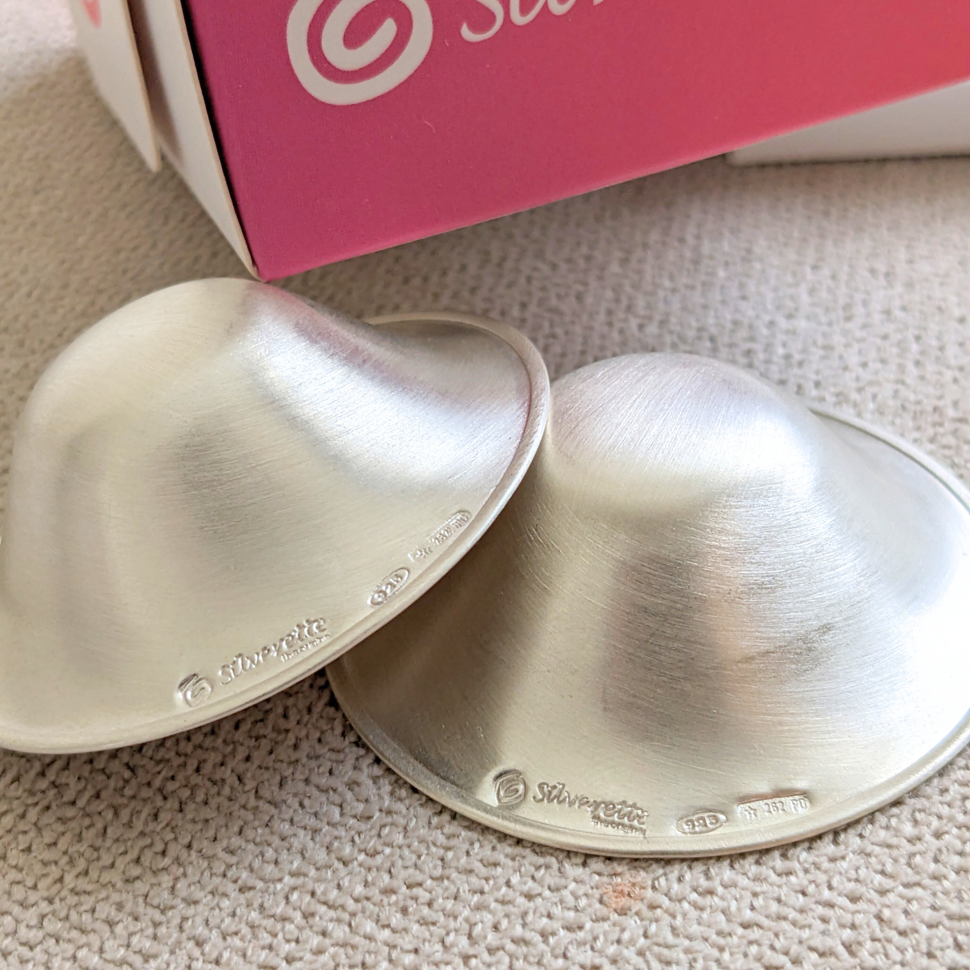 Close-up of Silverette Silverette Nurturing Essentials Bundle with silver nipple shields and nurturing accessories on a soft background.