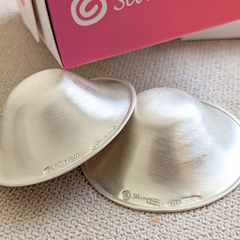 Close-up of Silverette Silverette Nurturing Essentials Bundle with silver nipple shields and nurturing accessories on a soft background.